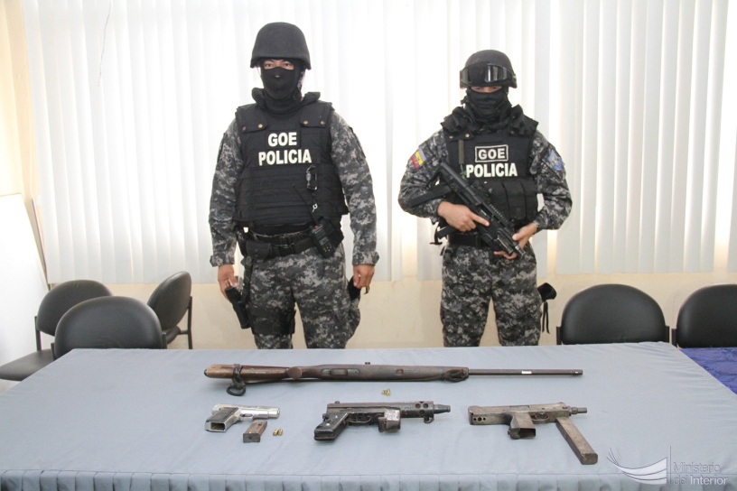 Dos policías del GIR custodian unas armas de fuego decomisadas en Murachi, San Isidro. Manabí, Ecuador.
