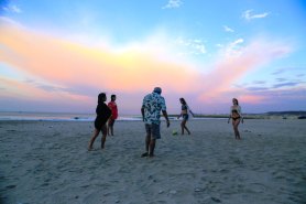 Turistas contemplan extasiados un atardecer en la Playa San Mateo, de la ciudad de Manta.